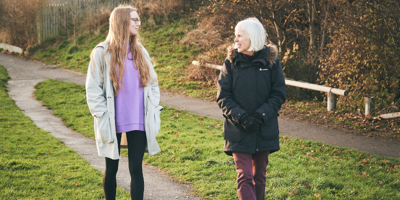 A young woman and an older woman taking a walk outdoors.