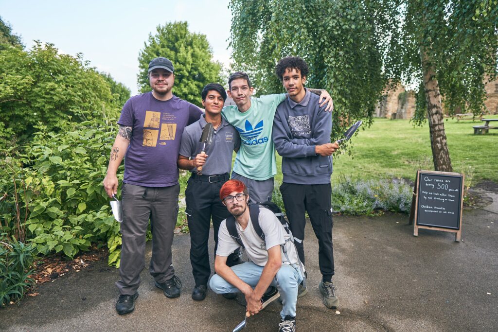 Five young men gathered in a close group looking proud and happy.