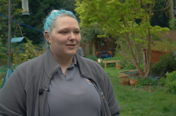 Female dressed in grey with blue hair, stood in a garden_Grow Sheffield