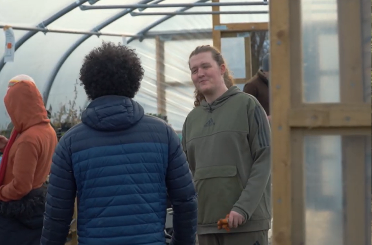 Three people socialising in a polytunnel_Grow Sheffield