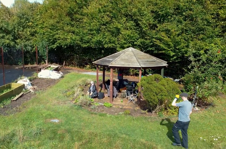Wooden pergoda in an outdoor green space and two people_Grow Sheffield
