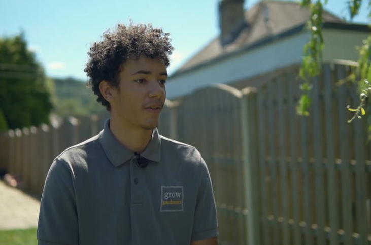 Young male in grey polo shirt stood in a garden with fence background_Grow Sheffield