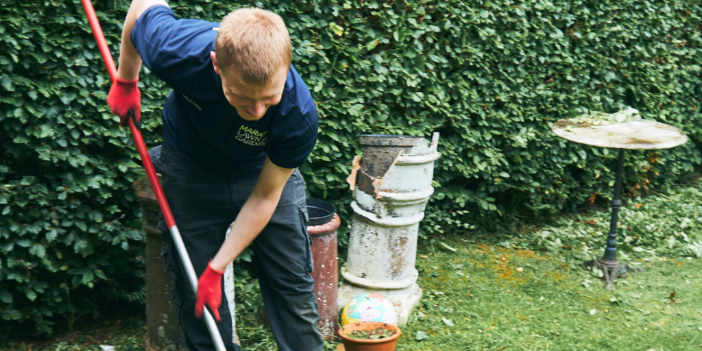 Male using a gardening tool in a garden.