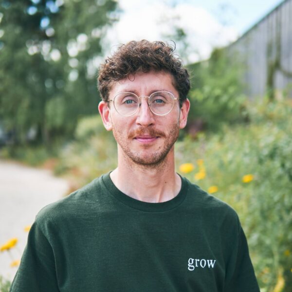 Man wearing green t-shirt and glasses stood outside