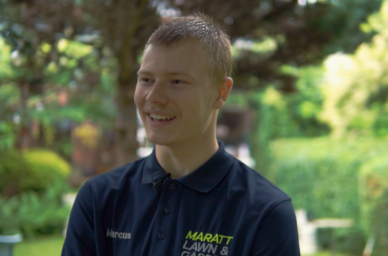 Young man in a garden smiling