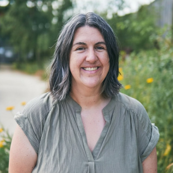 Woman stood outside wearing a pale green shirt
