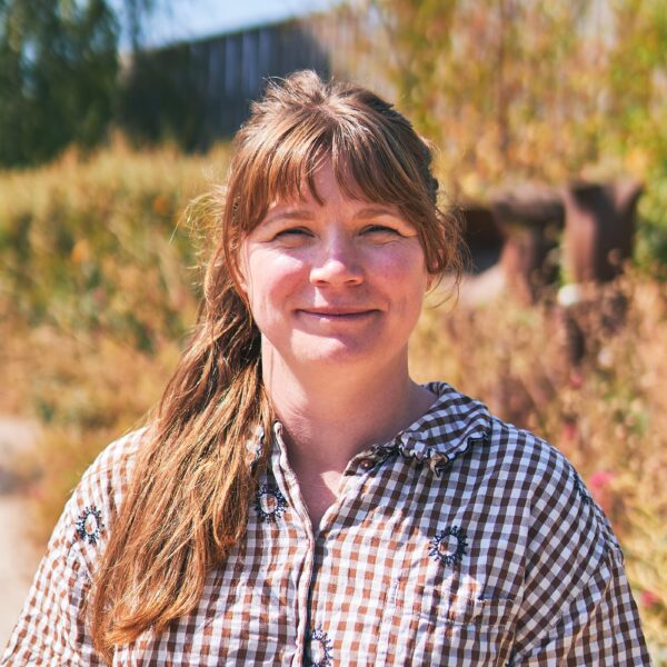 Woman wearing checked shirt stood outside